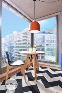 einen Tisch und einen Stuhl in einem Zimmer mit einem großen Fenster in der Unterkunft Vistas Panorámicas al Parque in Montevideo
