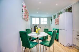 a kitchen and dining room with a table and green chairs at Amazing place in Finsbury Park in London