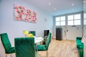 a dining room with a table and green chairs at Amazing place in Finsbury Park in London