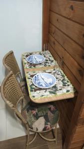 a table with two chairs and a table with plates on it at Suíte privativa 11km vila germânica in Blumenau