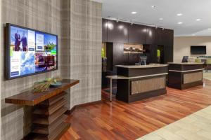 a lobby with a reception desk and a tv on a wall at Courtyard Memphis Downtown in Memphis