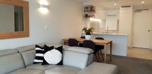 a living room with a couch and a table at The Atrium in Mount Maunganui