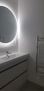 a bathroom with a white sink and a mirror at The Atrium in Mount Maunganui