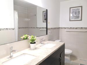 Baño con 2 lavabos y espejo en spacious and bright house, en Toronto