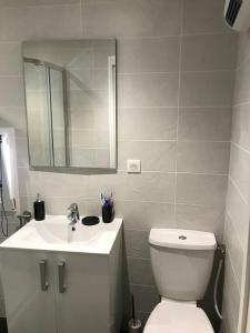 a bathroom with a white toilet and a sink at Maison de village in Laurens