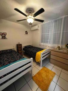 a bedroom with two beds and a ceiling fan at Cozy in Cabo1 