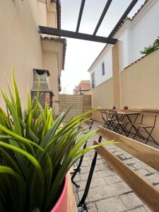 um pátio com um banco, uma mesa e plantas em Apartamentos Sevilla Deluxe Rosales em Los Rosales