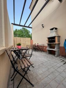 a patio with a table and chairs and a fireplace at Apartamentos Sevilla Deluxe Rosales in Los Rosales