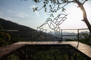 a metal sculpture on top of a wooden deck at Colores de la Sierra in Minca