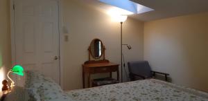 a bedroom with a bed and a lamp and a mirror at Oceanfront Garden Cottage - Gateway to Attractions and Towns, Private Cove Mooring in Chester