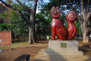 a cat statue in a park with trees in the background at Hotel Avenida 3 Real en el norte de Cali in Cali