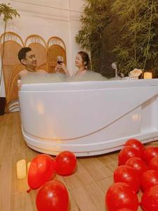 Un uomo e una donna in una vasca da bagno con palloncini rossi di Stellar Homesharing (Home #2) a Davao