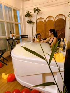 Un uomo e una donna in una vasca da bagno di Stellar Homesharing (Home #2) a Davao