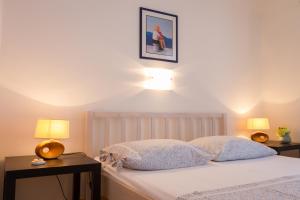 1 dormitorio con 1 cama con 2 mesas y 2 lámparas en Apartments by the sea Stomorska, Solta - 5190 en Stomorska