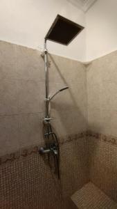 La salle de bains carrelée est pourvue d'une douche. dans l'établissement Appartement de Mustapha larache, à Larache