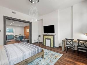 een slaapkamer met een bed, een open haard en een televisie bij Luxury and Stylish 2Bedroom Apartment on Carson, South Flats, Pittsburgh in Pittsburgh