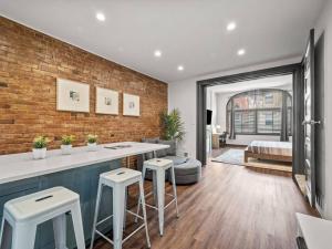 a kitchen with a counter and stools in a room at Luxury and Stylish 2Bedroom Apartment on Carson, South Flats, Pittsburgh in Pittsburgh