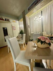 a dining room with white chairs and a table with flowers on it at Hotel La Pergola in Rionero in Vulture