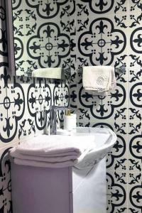 a bathroom with a white sink and a black and white wallpaper at Deniz ve Doğa iç içe Tatil in Ayvalık