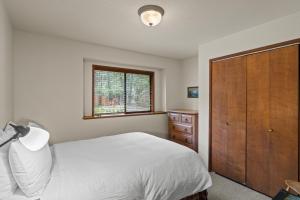 una camera con letto bianco e armadio in legno di The River House a Rogue River