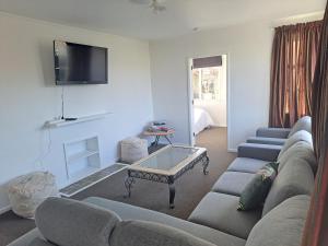 uma sala de estar com um sofá e uma mesa de centro em 3bdrm plus Sleepot Home, em Nelson