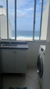 a bathroom with a sink and a view of the ocean at Deslumbrante Vista Mar na Praia de Copacabana in Rio de Janeiro