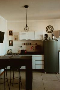 a kitchen with a refrigerator and a table with chairs at Cantinho da Ernesto in Santa Maria