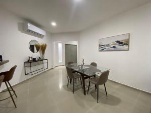 a dining room with a glass table and chairs at Departamento colonia Carrizal in Villahermosa