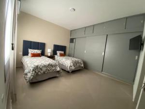 a bedroom with two beds and a table in it at Departamento colonia Carrizal in Villahermosa
