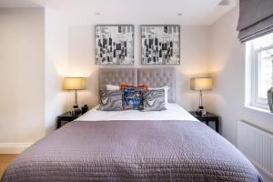 a bedroom with a large bed with two lamps at Luxury 3 Bed Mayfair Apartment in London