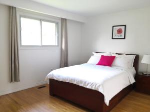 1 dormitorio con cama grande y almohada rosa en spacious and bright house, en Toronto