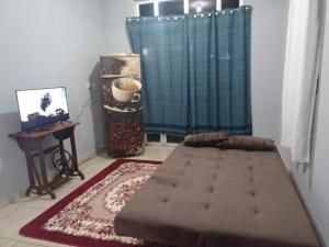 een slaapkamer met een bed, een bureau en een raam bij Kit net flor de café in Caparaó Velho