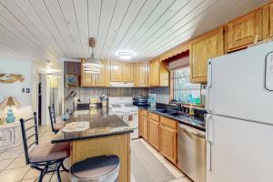een keuken met houten kasten en een witte koelkast bij Salt Creek Cottage in Weeki Wachee
