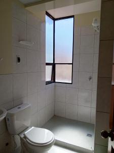 a bathroom with a toilet and a window at Jhonyximena in Copacabana