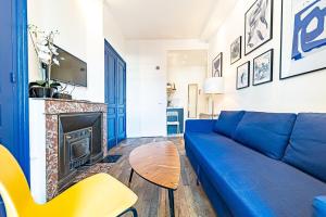 sala de estar con sofá azul y chimenea en Le petit Charlemagne- Studio Rénové -Perrache, en Lyon