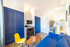 sala de estar con sofá azul y chimenea en Le petit Charlemagne- Studio Rénové -Perrache, en Lyon