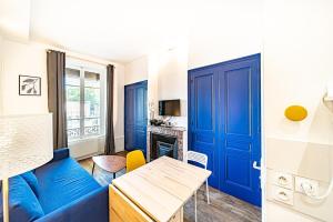 a living room with a blue couch and a table at Le petit Charlemagne- Studio Rénové -Perrache in Lyon