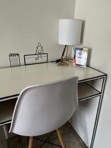 un escritorio con una silla y una lámpara. en Casa Cariño •Room 2•, en Ciudad Guzmán