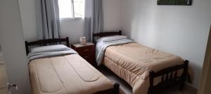 2 camas en una habitación pequeña con ventana en Río de Chocolate en Santa María