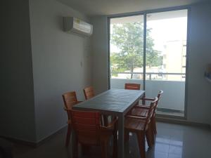 a dining room table with chairs and a window at Cómodo apartamento cerca al mar in Coveñas