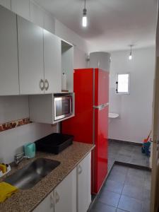 eine Küche mit einem roten Kühlschrank und weißen Schränken in der Unterkunft Río de Chocolate in Santa María