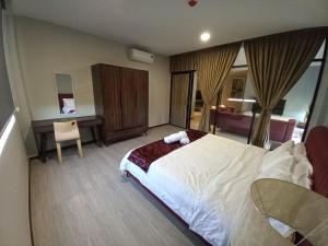 a bedroom with a bed and a desk and a chair at KAN JIA in Miri