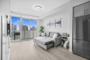 a living room with a couch and a large window at Luxury Downtown Toronto 2 Bedroom Suite with City and Lake Views and Free Parking in Toronto