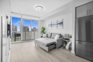 uma sala de estar com um sofá e uma grande janela em Luxury Downtown Toronto 2 Bedroom Suite with City and Lake Views and Free Parking em Toronto