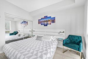 1 dormitorio con 1 cama y 1 silla azul en Luxury Downtown Toronto 2 Bedroom Suite with City and Lake Views and Free Parking en Toronto