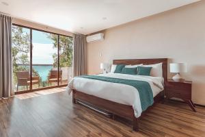a bedroom with a bed with a view of the ocean at MBH Maya Bacalar Hotel Boutique in Bacalar +34 photos