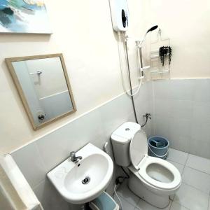 a bathroom with a toilet and a sink and a mirror at Stellar Homesharing (Home #2) in Davao City