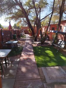 a walkway in a yard with tables and chairs at Hostal Perita in San Pedro de Atacama