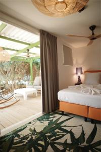 a bedroom with a bed and a patio at The Lizard Boutique Hotel in Kralendijk