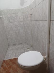 a bathroom with a white toilet in a shower at Kit net flor de café in Alto Caparao